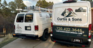 Curtis and Sons Plumbing and HVAC service work vehicles parked outside of a house call in Parker, CO